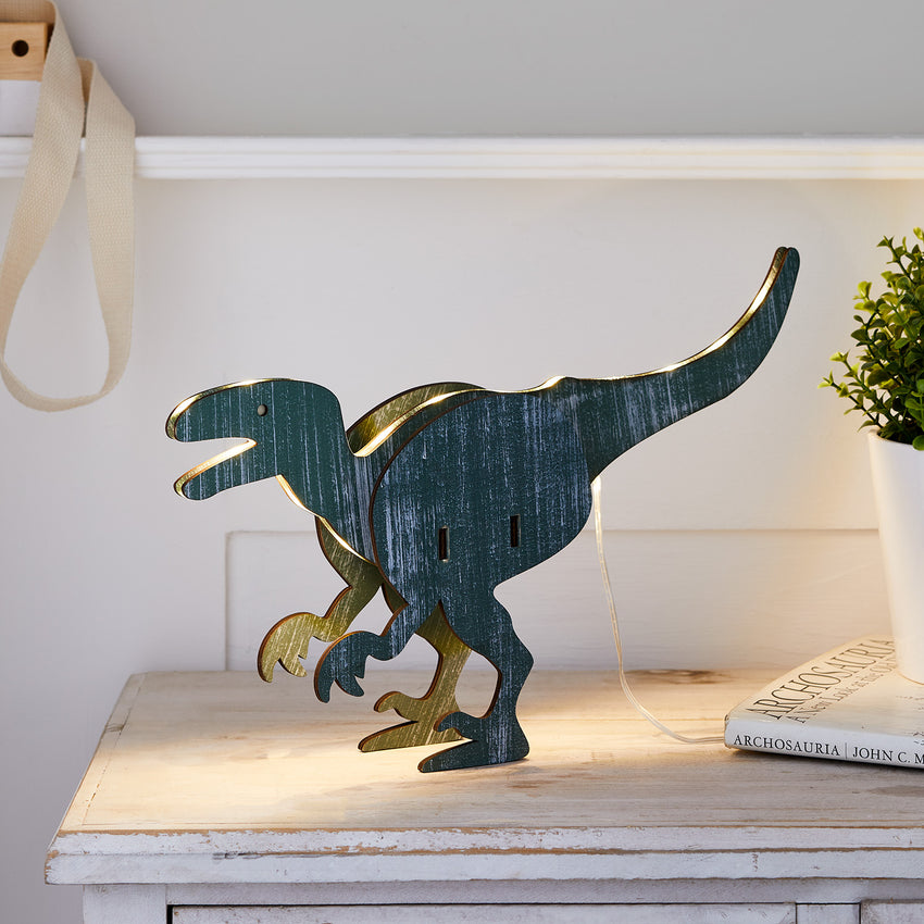 T-Rex Tischlampe aus Holz fürs Kinderzimmer auf einer weißen Kommode