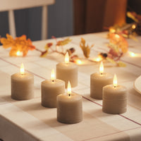 Weiße TruGlow LED-Kerzen mit warm flackernder Flamme auf einem gedeckten Gartentisch mit Blumen