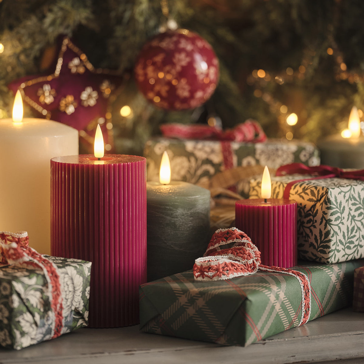 Weihnachtliches Tischgesteck mit 3 pflaumenfarbenen TruGlow® LED-Stumpenkerzen und Fernbedienung