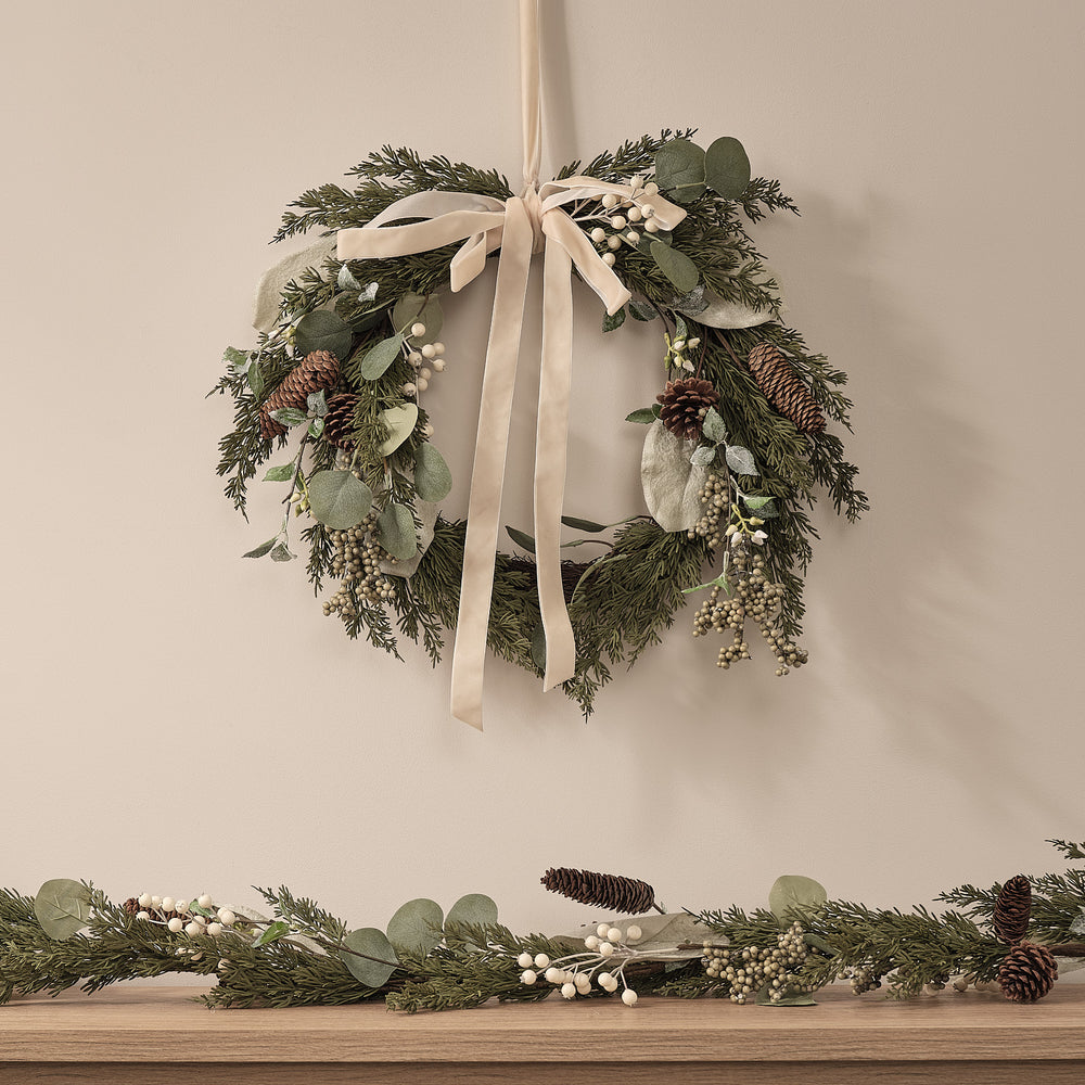 Weihnachtskranz mit weißen Beeren und Tannenzapfen