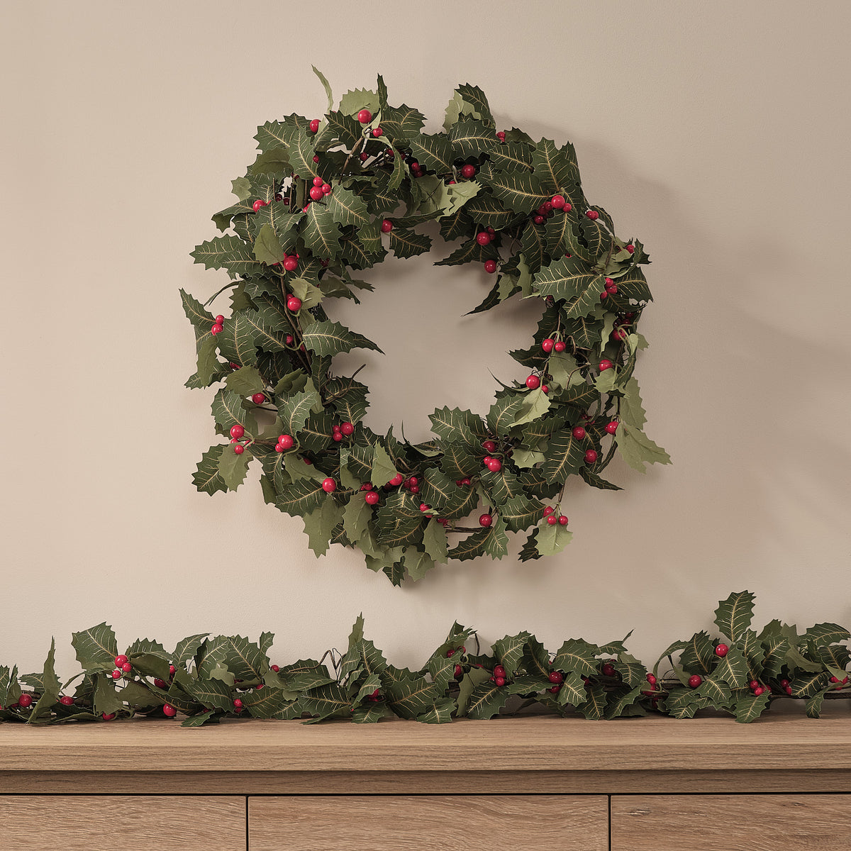 Weihnachtskranz und Weihnachtsgirlande mit Stechpalme und Beleuchtung