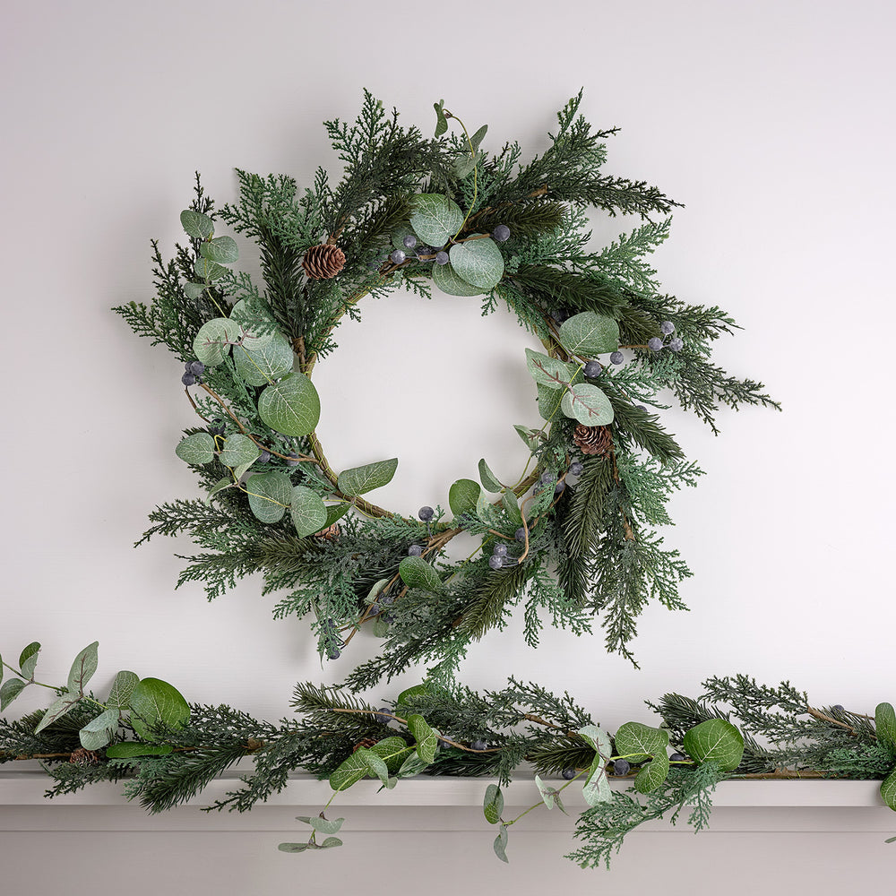 Weihnachtskranz und Weihnachtsgirlande blaue Beeren und Tannenzapfen