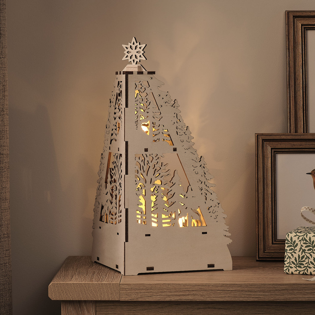 35cm LED-Winterlandschaft aus Holz mit Blockhütte und Timer beleuchtet auf Schrank von hinten
