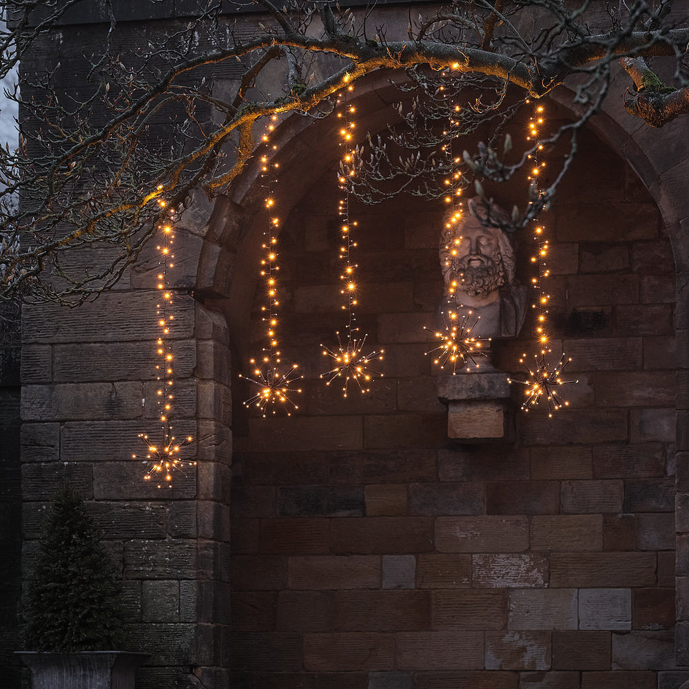 Warmweiße LED-Starburst-Hängedeko für Bäume außen mit Blinkeffekt am Baum