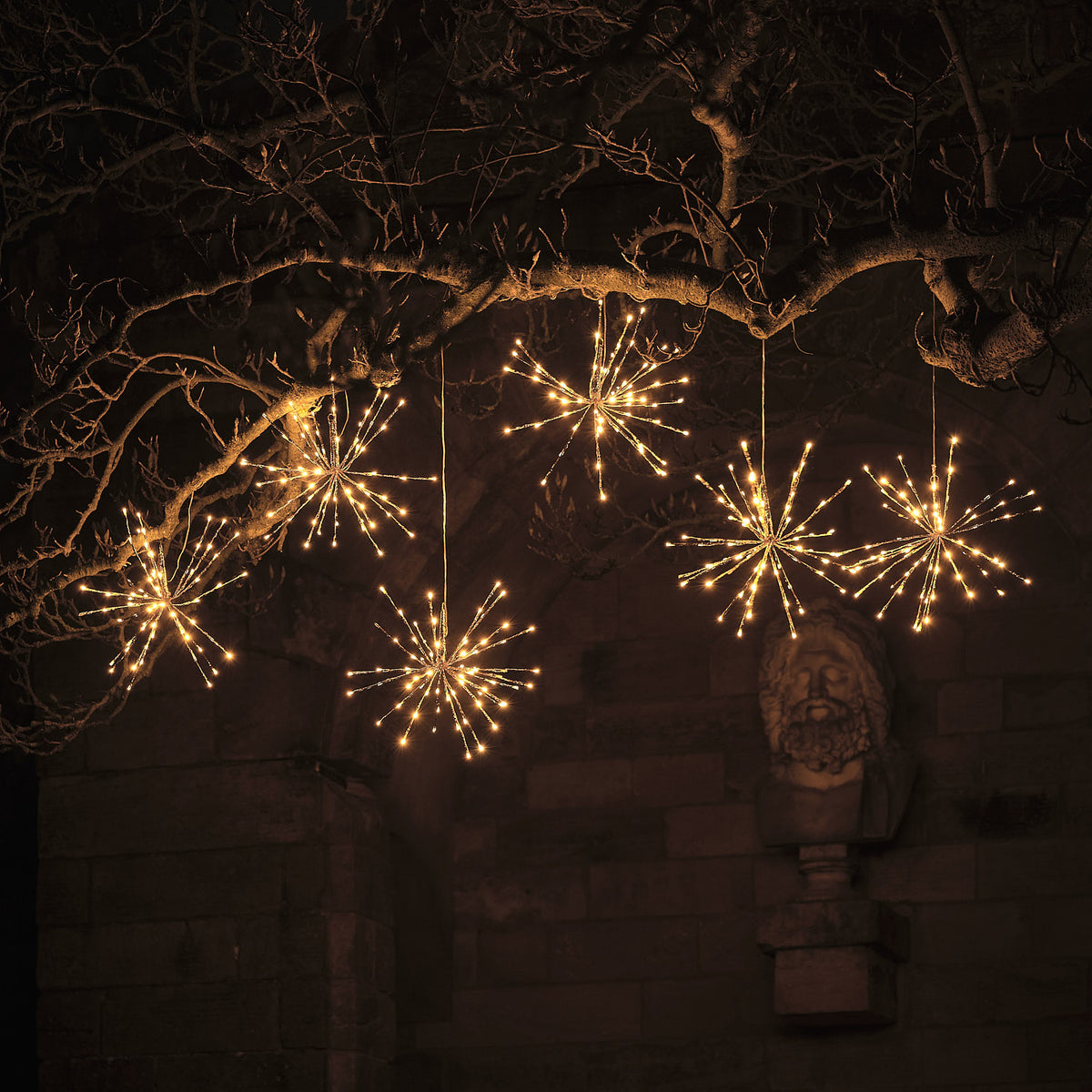 Festliche mehrfache Anordnung von hängenden LED-Stern-Dekofiguren mit warmweißer strahlenförmiger Beleuchtung, integriert in rustikalem Gartenbogen mit natürlichen Holzstrukturen – luxuriöse dekorative Hänge-Lichterketten-Kollektion für umfassende Premium-Außen-Weihnachtsdisplays.
