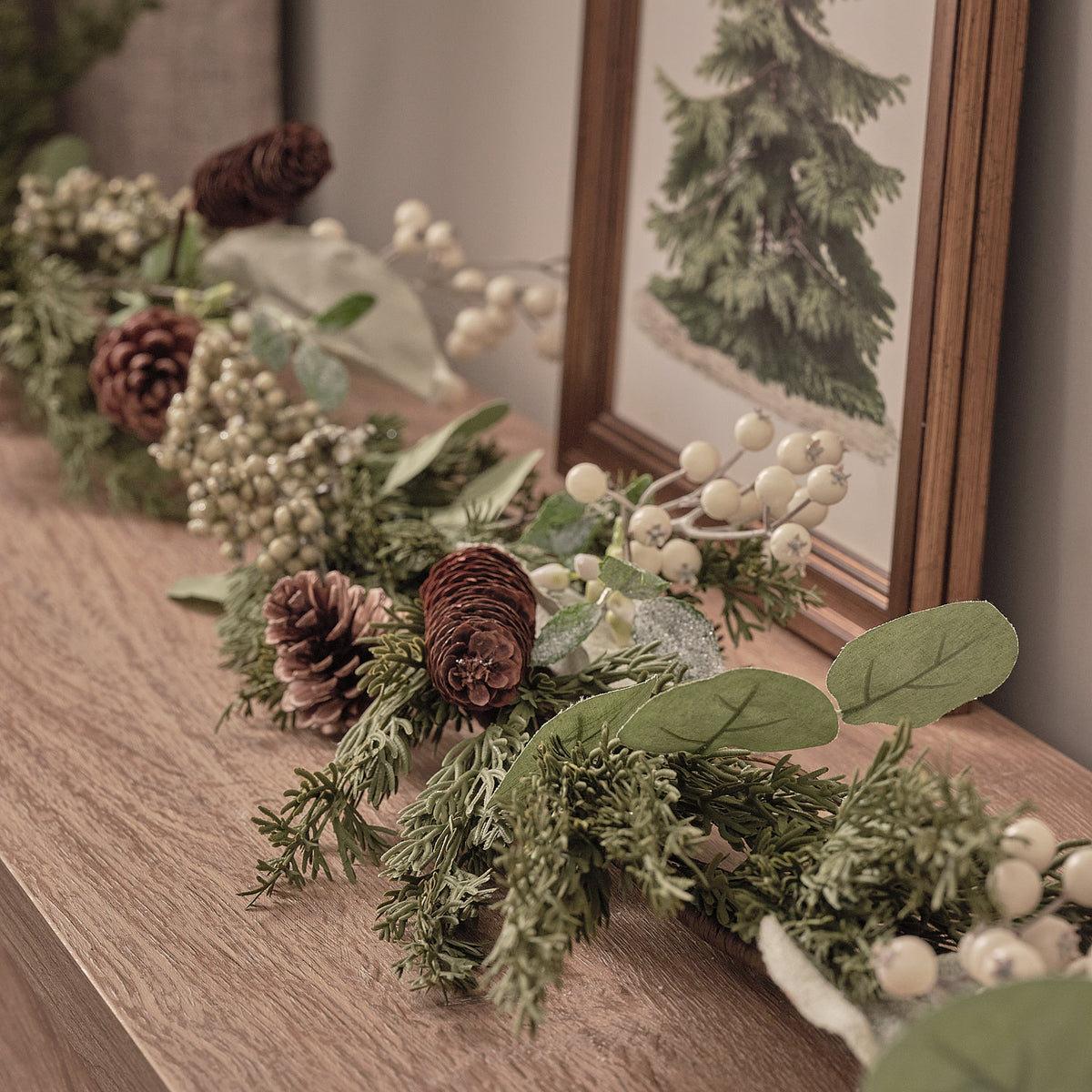 Weihnachtskranz und Girlande mit weißen Beeren und Tannenzapfen