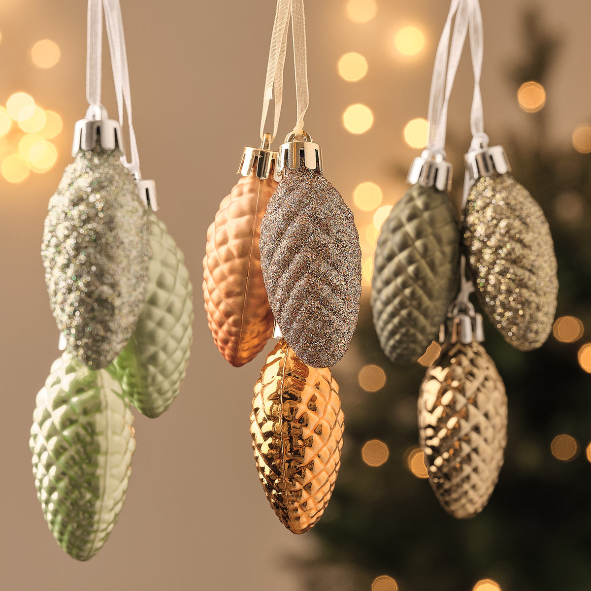 Braune und kupferfarbene Tannenzapfen an Nadelzweigen mit LED-Beleuchtung, Weihnachtliche Naturdekoration.