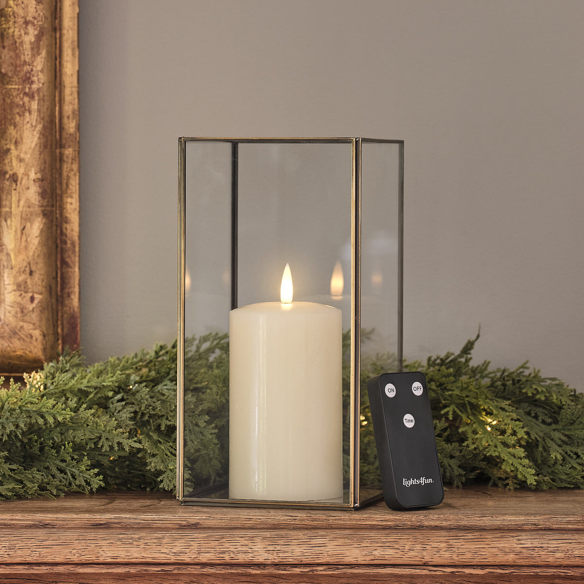 Goldene Metall-Laterne mit LED-Kerze neben Tannengrün auf Holzsims.
