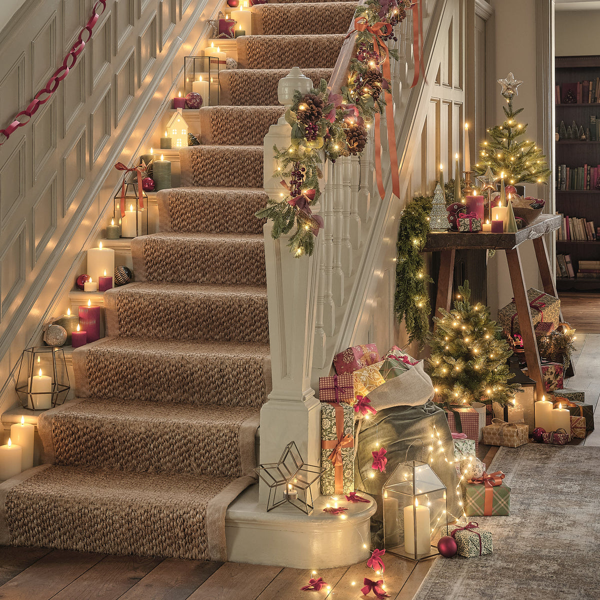 Weihnachtlich dekorierte Treppe mit Lichterkette und Geschenken.