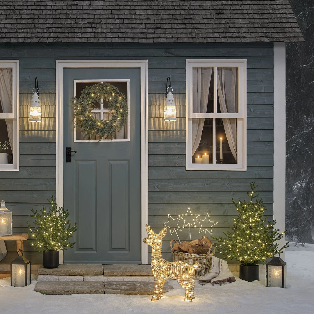 Weihnachtlich dekorierter Hauseingang mit Laterne, Kranz und Lichterkette.