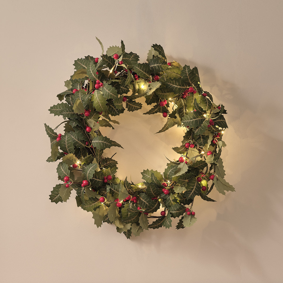 Weihnachtskranz und Weihnachtsgirlande mit Stechpalme und Beleuchtung
