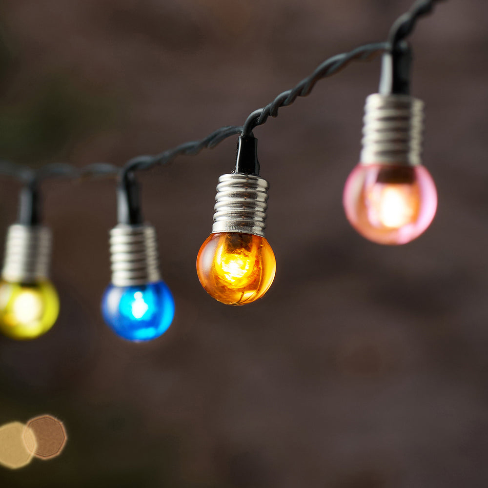 Nahaufnahme bunter LED-Kugeln an schwarzem Kabel mit warmweißem Licht
