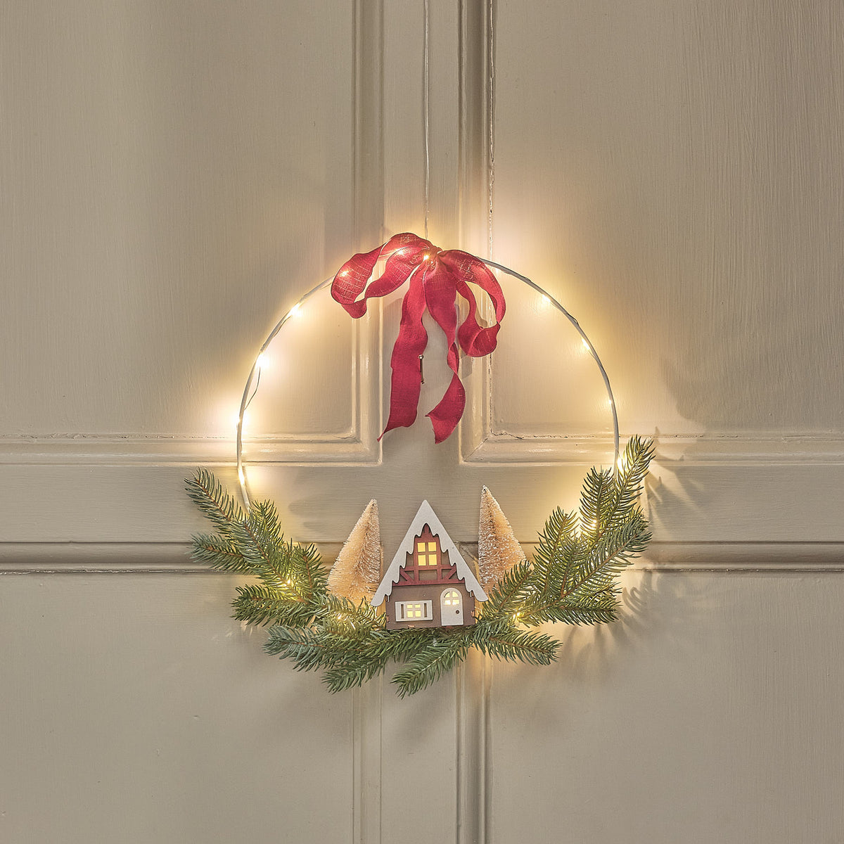 30cm LED-Weihnachtskranz mit Häuserszene und bordeauxroter Schleife
