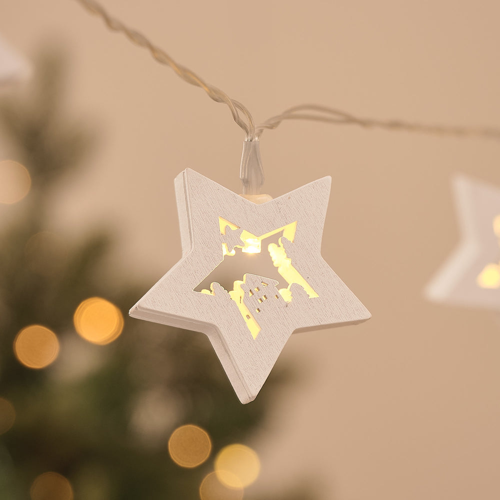 10er LED-Lichterkette mit weißen Holzsternen und Weihnachtsmotiv beleuchtet close up