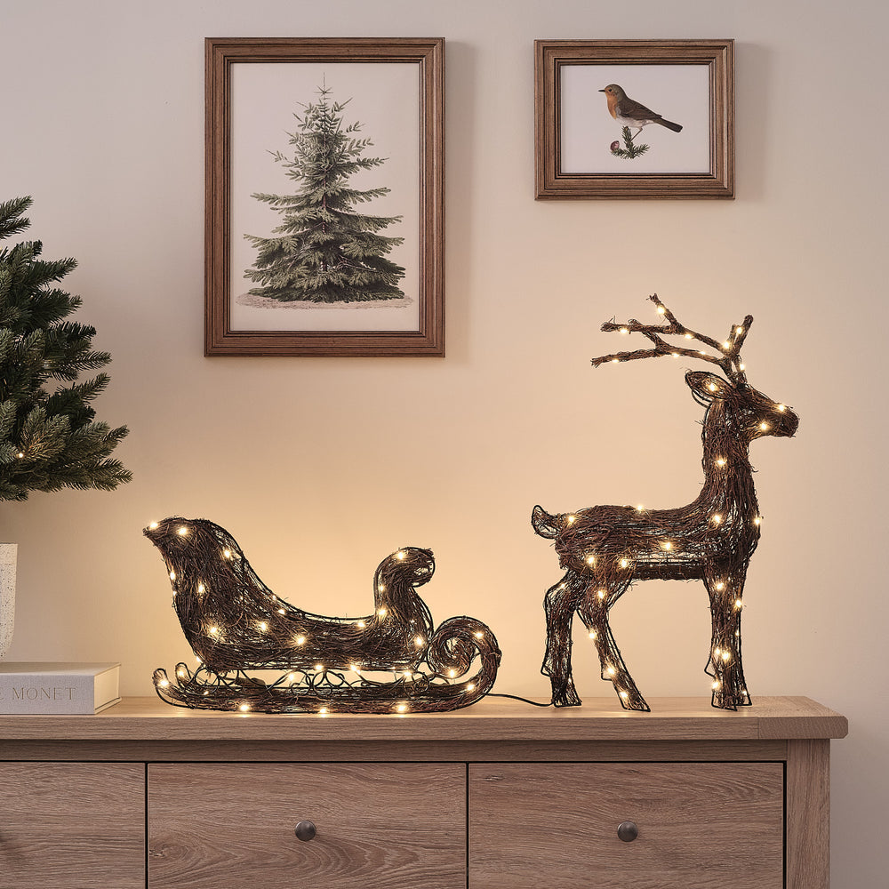 Helmsley 50 cm Bicolor LED-Rentier mit Schlitten aus Naturzweigen