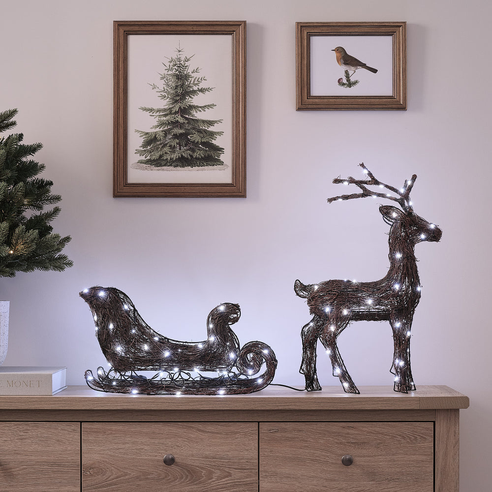 Helmsley 50 cm Bicolor LED-Rentier mit Schlitten aus Naturzweigen