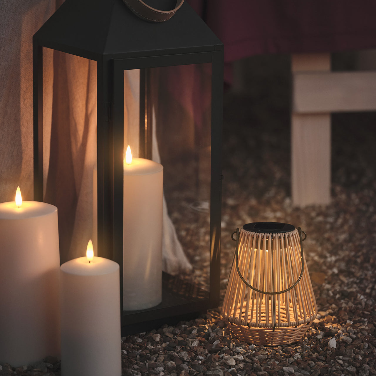 Hygge Solar-Laterne in Rattanoptik mit warmweißer LED angerichtet neben Laternen