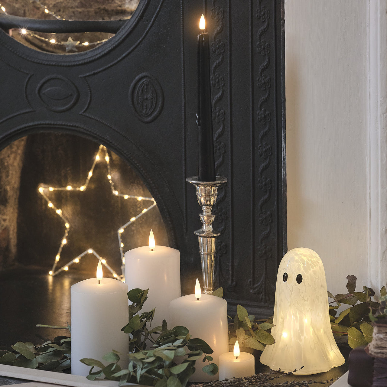 Große Gertie LED-Halloween-Geist-Deko aus Konfettiglas neben Kerze