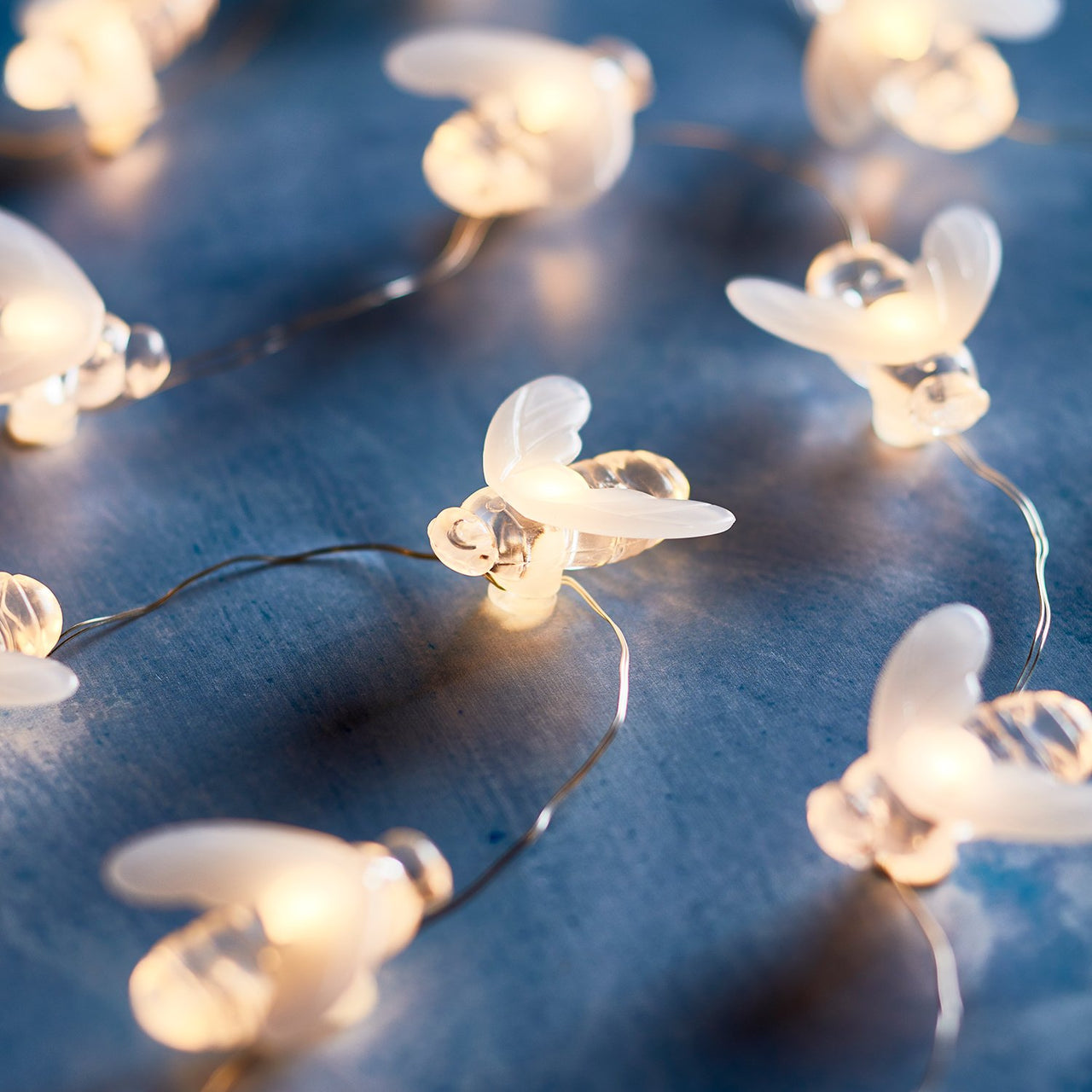 Bienen Lichterkette mit warmweissen LEDs auf blauem Untergrund.