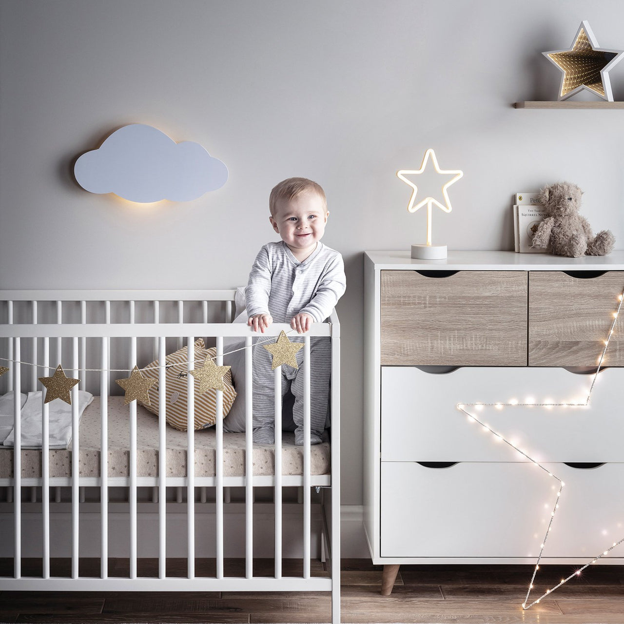 Babyzimmer mit Wolken Wandlicht an weißer Wand mit Sternen und Baby.