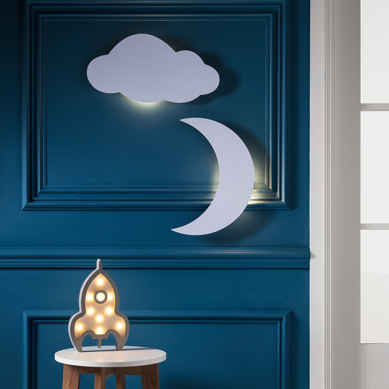 LED Wolke und Mond in Weiß an dunkelblauer Wand mit LED Rakete.