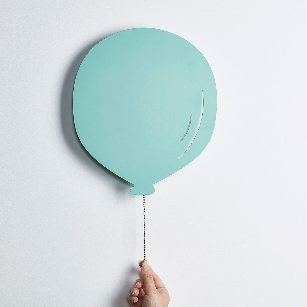Ausgeschaltete Luftballon Wandleuchte mit Hand an Schalter.