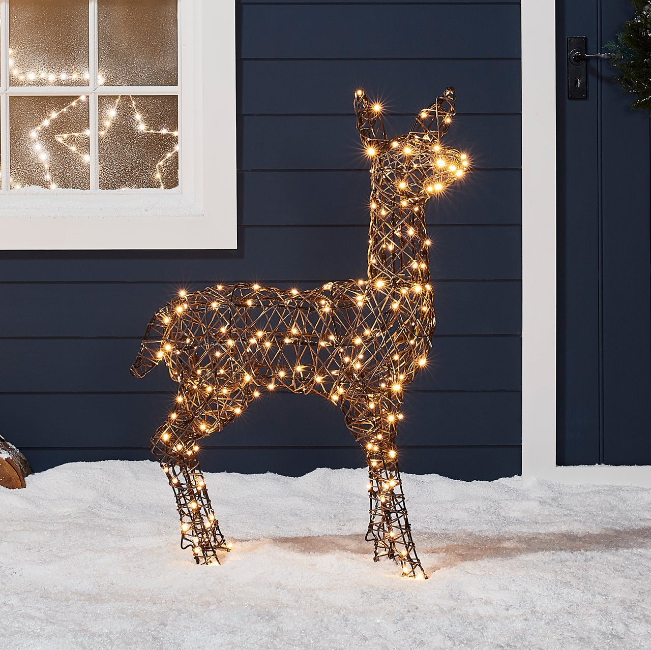 LED-Rentier-Mutter beleuchtet im Schnee.